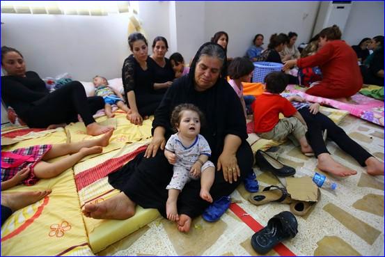 Iraqi Christian families who have fled from Mosul and other nearby towns ahead of advances by Sunni militants gather at a social club in a suburb of Kurdish-controlled Erbil on Thursday (AP photo).