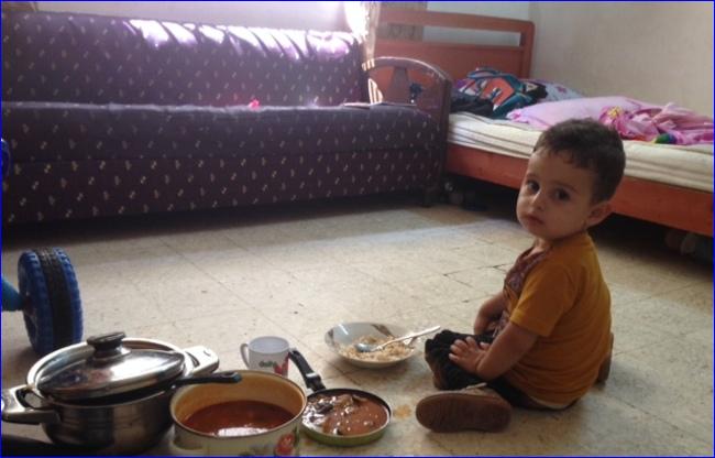 2-year-old Behnam Atallah sits on the floor of a small room in Jdeideh, where he lives with his parents and sisters after his family fled from ISIL in Iraq (photo: Nohad Topalian/Al-Shorfa).