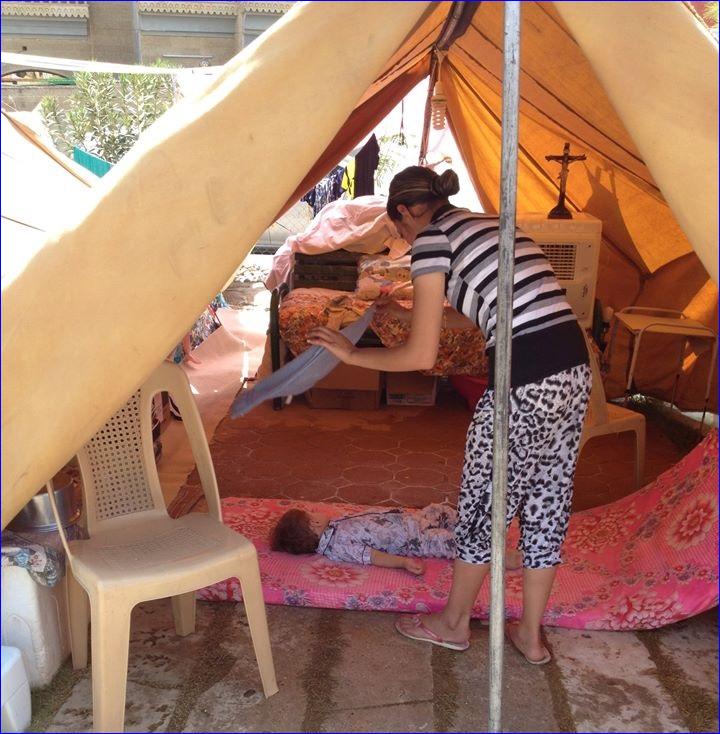 An Assyrian mother fans her child at a refugee camp in Ankawa. The temperature was 115F (46C).