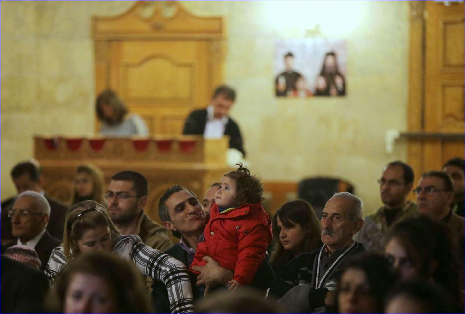 Syrian Christans look on during Divine Liturgy at the Greek Orthodox church in the Syrian government controlled area of Aleppo on November 16, 2014 (AFP).