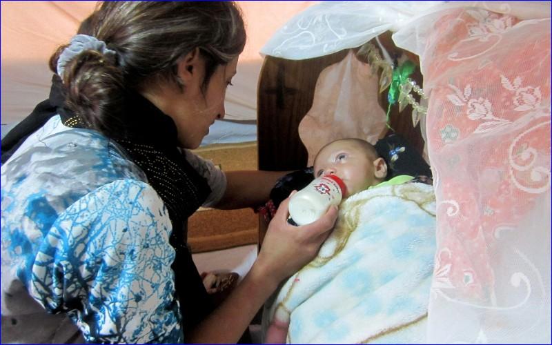 When baby Mariam was born her mother laid her in a bed made from a plastic bag Below: Refugees in a camp near Erbil (CNS).