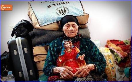 An elderly Christian woman, made homeless by ISIS attacks on the minority in Iraq, sits with her belongings in the Kurdistan Region.