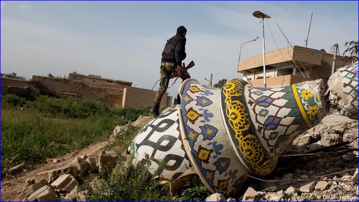 A Syriac Military Council soldier walks among ruins of the Mosque in Tel Marouf, a town recently retaken from IS forces. The Islamic State fighters have left a trail of destruction in many areas, breaking and looting valuable cultural artifacts.