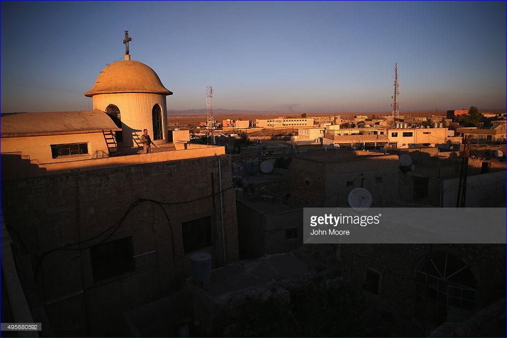 A Christian militiaman looks towards the ISIS frontline from St. George's Church on November 4, 2015 in Telskuf, northern Iraq. All of the town's 11,000 predominantly Chaldean Catholic residents fled when it was overrun by the Islamic State in 2014 before being retaken by Peshmerga forces with the aid of American airstrikes. Of the 1,800 families that fled, some 40 percent left Iraq, according to Safaa Khamro, commander of the Nineveh Plain Forces (NPF), Christian militia. Many, he said, have now immigrated to Europe.